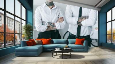 cropped shot of young business people with tattoos standing with crossed arms in office Wall mural