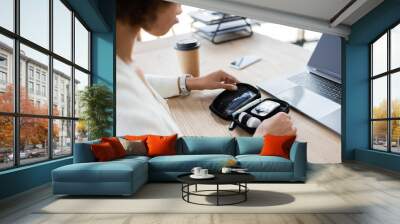 Cropped view of african american businesswoman holding diabetes kit near gadgets and coffee in office Wall mural