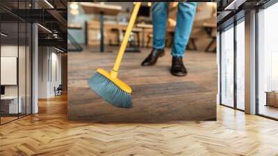 cropped view of african american worker sweeping with broom in coffee shop Wall mural