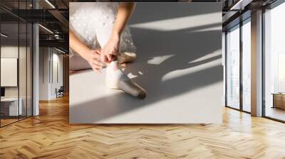 Cropped view of ballerina wearing pointe shoe on grey background with light Wall mural