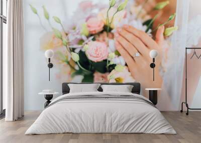 Cropped view of bride with jewelry ring on finger touching flowers in bouquet Wall mural