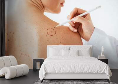 cropped view of dermatologist applying marks on skin of naked woman with melanoma isolated on white Wall mural