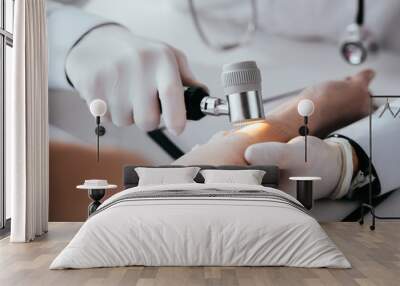 cropped view of dermatologist examining hand of woman while holding dermatoscope Wall mural