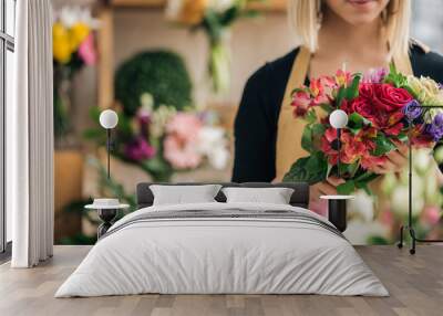 Cropped view of florist in apron holding bouquet in flower shop Wall mural