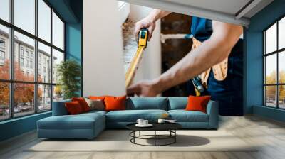 cropped view of handyman measuring wall with yellow measuring tape Wall mural