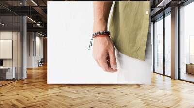 cropped view of male hand with bracelets against white wall Wall mural