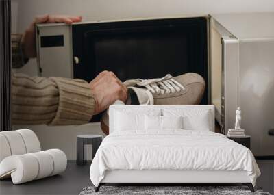 cropped view of senior man putting shoe inside of microwave Wall mural