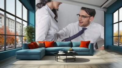 cropped view of sexy businesswoman touching tie of excited colleague while seducing him in office Wall mural