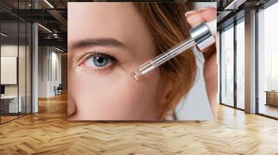 Cropped view of woman applying cosmetic serum on face isolated on grey, banner Wall mural