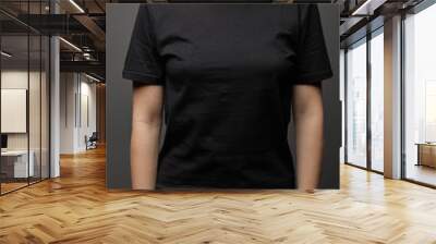 cropped view of woman in blank basic black t-shirt on black background Wall mural