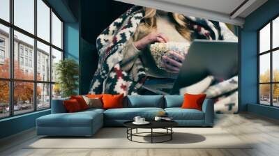 cropped view of woman watching movie on laptop and holding bowl with popcorn Wall mural