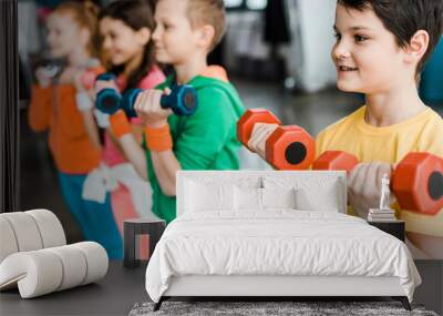 Cute children training with colorful dumbbells Wall mural