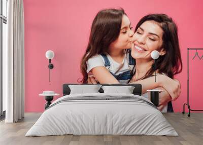 daughter kissing happy mother isolated on pink Wall mural