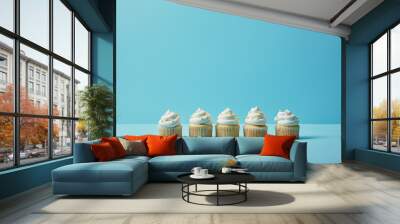 Delicious cupcakes with sugar sprinkles on blue background Wall mural