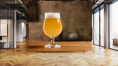 delicious fresh beer with foam in glass on wooden table in bar Wall mural