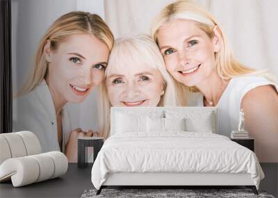 elegant three-generation blonde women in total white outfits Wall mural