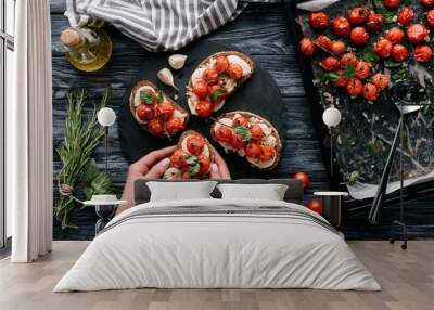 Female chef cooking sandwiches with cheese and baked tomatoes on dark wooden table Wall mural