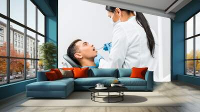 female dentist in latex gloves examining african american patient Wall mural