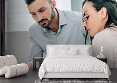 female psychiatrist talking with patient and showing clipboard in office Wall mural