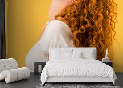 female redhead student with book on face isolated on yellow Wall mural