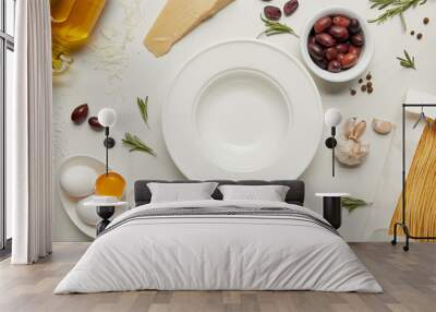 flat lay with empty plate and pasta ingredients on white marble surface Wall mural