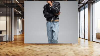 full length of stylish african american man in jeans and leather jacket posing on grey. Wall mural