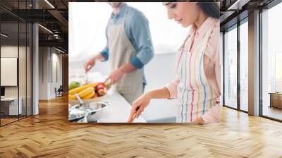 girlfriend frying vegetables on frying pan in kitchen Wall mural