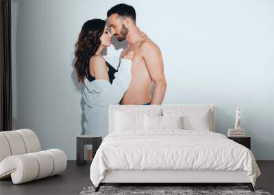 girlfriend in white shirt embracing with boyfriend on grey Wall mural