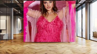 glamorous young woman in pink feathered robe and gloves looking at camera in luxurious setting Wall mural