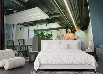 group of creative business partners walking in modern and spacious coworking space with high tech interior, contemporary furniture and green natural plants, movement, long exposure Wall mural