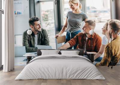 group of young entrepreneurs talking while working on startup together at office Wall mural