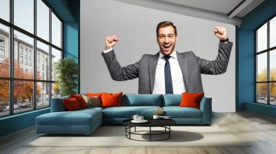 handsome and smiling businessman in suit showing yes gesture isolated on grey Wall mural