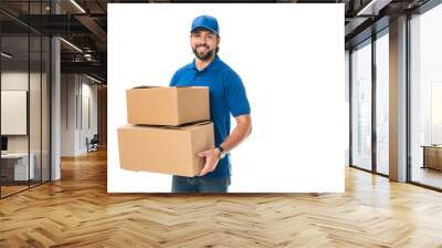 handsome happy young delivery man holding cardboard boxes and smiling at camera isolated on white Wall mural