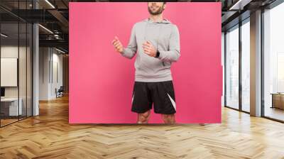 handsome sportsman throwing up soccer ball isolated on pink Wall mural