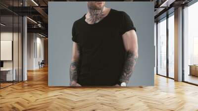 handsome tattooed man posing in casual clothes, isolated on grey Wall mural