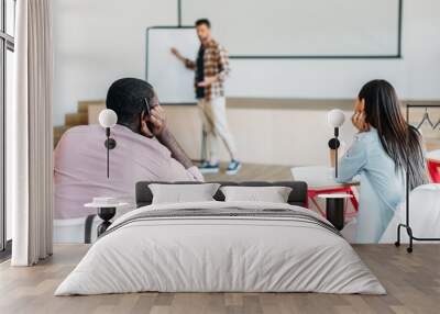 handsome young teacher making presentation for group of students at university Wall mural