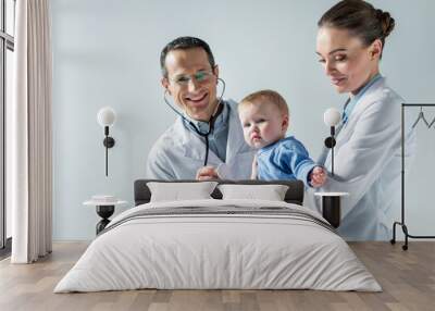 happy adult pediatricians taking care of little baby isolated on grey Wall mural