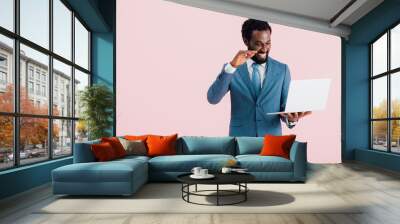 happy african american businessman having video chat on laptop isolated on pink Wall mural