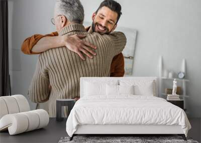 happy bearded man smiling while hugging elder father at home Wall mural