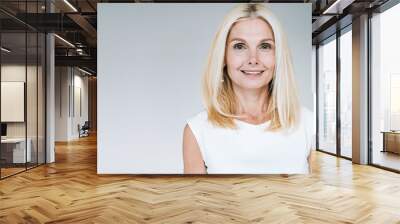 happy blonde mature woman smiling isolated on grey Wall mural