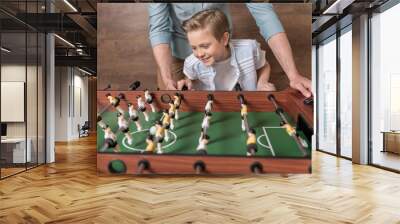 Happy boy playing foosball together with father Wall mural