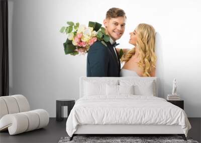 happy bride with wedding bouquet hugging smiling groom isolated on white Wall mural