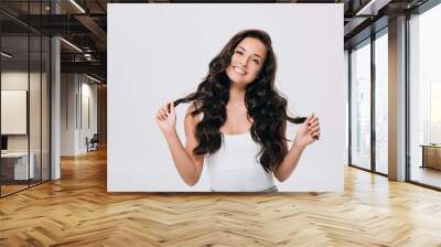 happy brunette beautiful woman with long curly healthy hair isolated on grey Wall mural