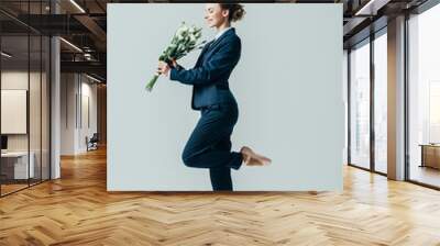 happy businesswoman in suit and ballet shoes with bouquet of flowers, isolated on grey Wall mural