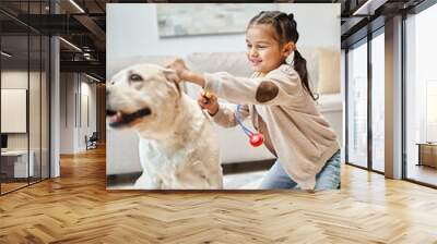 happy child in casual attire playing doctor with labrador in modern living room, toy stethoscope Wall mural