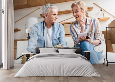 happy elderly couple counting money and laughing while moving home Wall mural