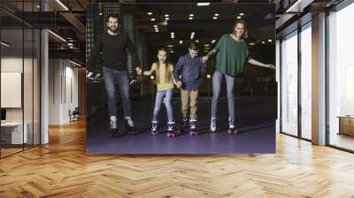 happy family holding hands while skating together on roller rink Wall mural