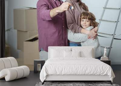 happy family with one kid smiling at camera and holding key from new apartment Wall mural