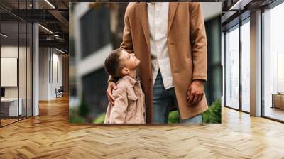 happy father and son embracing and looking at each other on street Wall mural