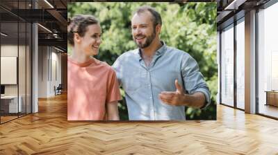 happy father hugging teenage son and walking together in green summer park, banner. Wall mural